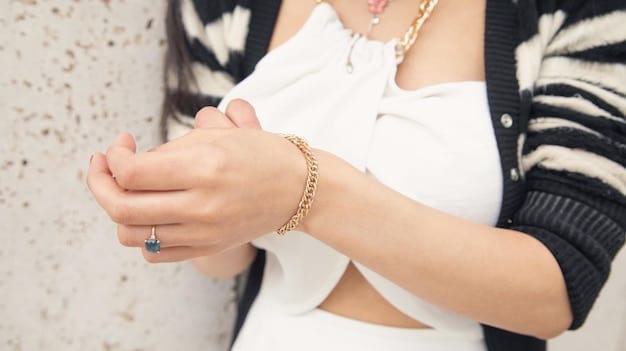 A close-up shot of a woman's hands showcasing layered gold bracelets and rings, emphasizing the trend of stacking delicate jewelry for a chic, effortless look.