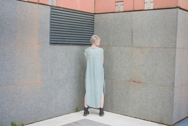 A woman standing in front of a brick wall, showcasing a layered outfit: a simple black turtleneck sweater, a partially unbuttoned denim jacket, and a long, flowing cardigan. She's wearing dark wash jeans and ankle boots. The look is both stylish and comfortable, showcasing the versatility of layering.