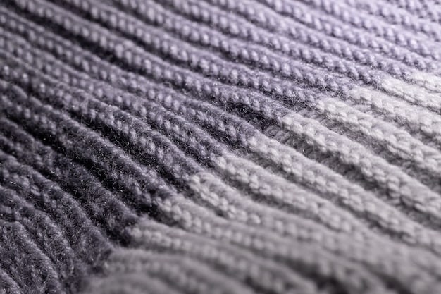 A close-up of different fabric textures in varying shades of gray, including knitted wool, smooth cotton, and textured linen. The image highlights the subtle differences in color and texture that create depth in a monochromatic outfit.