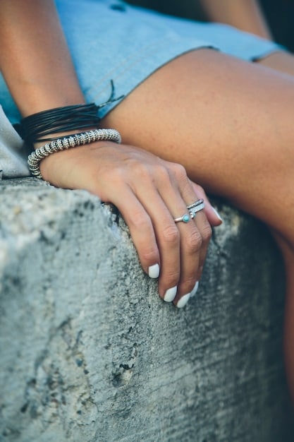 A close-up shot of a woman's hands, showcasing multiple rings on her fingers and a bracelet on her wrist, highlighting the art of accessorizing with jewelry.