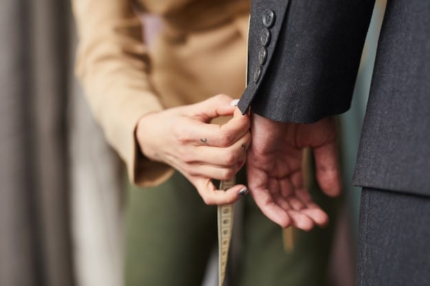 A fashion designer or tailor is adjusting the hem of a pair of pants on a client. The tailor is carefully pinning the fabric to ensure a perfect fit, highlighting the importance of tailoring in achieving a flattering silhouette.
