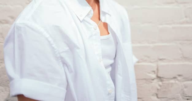 A close-up shot showcasing a selection of high-quality basic garments: a crisp white button-down shirt, a cashmere sweater in a neutral color, and a pair of well-fitting dark wash jeans. The focus is on the texture and quality of the fabrics.