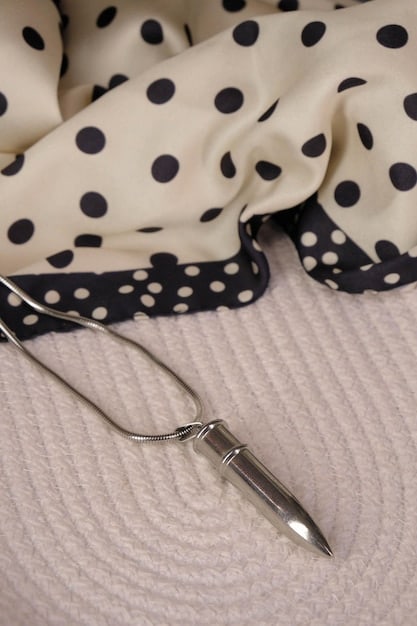 A close-up image showcasing a curated selection of French-inspired accessories: a silk scarf tied loosely around the neck, delicate gold hoop earrings, a classic leather crossbody bag, and a pair of simple black ballet flats. The background is a soft, neutral tone.