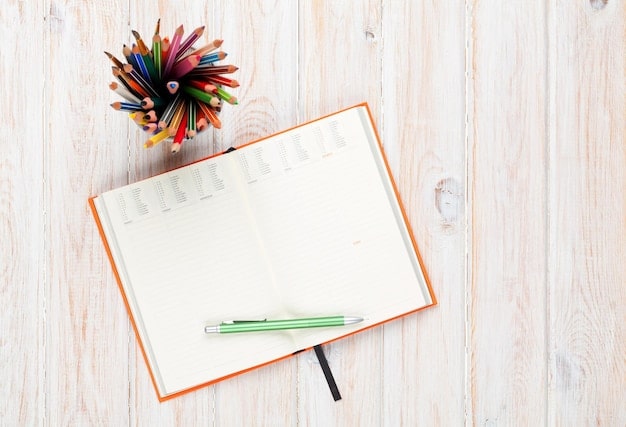 An open journal on a desk with several colorful pens scattered around. The journal page contains a list of insightful prompts. The overall image is bright and inspiring, conveying the potential for creativity and self-discovery through journaling.
