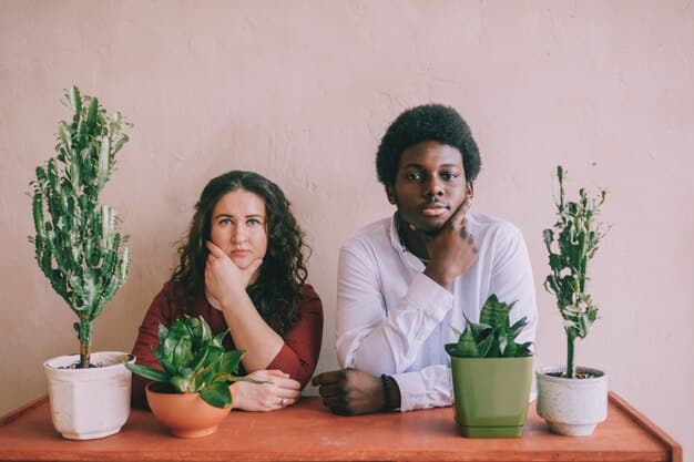Two individuals sitting across from each other, engaging in active listening with attentive body language and open expressions, in a bright office setting with plants.