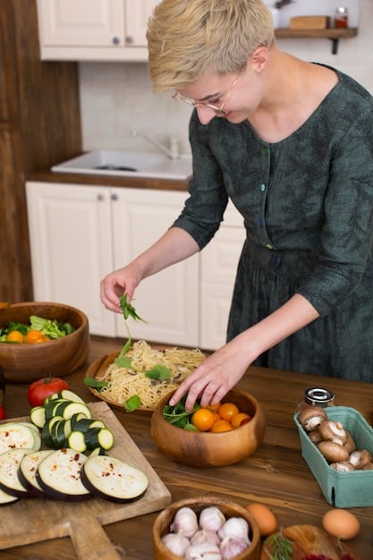 A close-up photo of a person preparing a nutritious meal with a variety of colorful vegetables, lean protein, and healthy fats on a kitchen counter.
