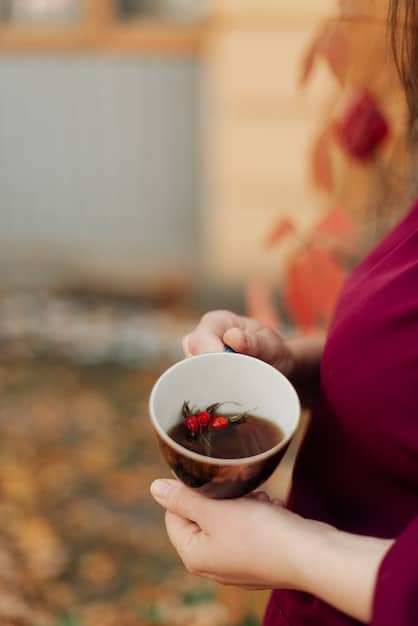 A calming image of a person drinking a cup of herbal tea, surrounded by stress-reducing foods like nuts, berries, and dark chocolate, creating a sense of relaxation and mindful eating.