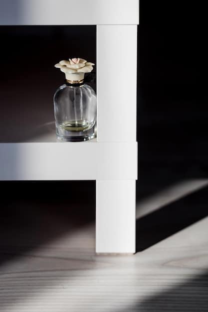 A close-up of a perfume bottle on a vanity, with direct sunlight shining through the window onto it.