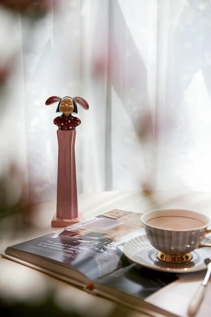 A close-up of various perfume bottles on a vanity, with light filtering through sheer curtains in the background, creating a dreamy and evocative atmosphere.