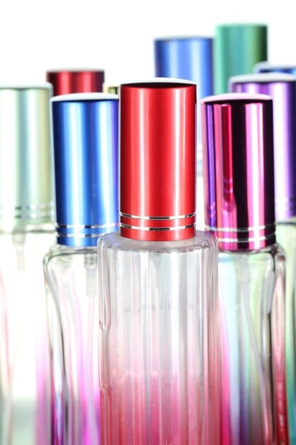 A close-up shot of various perfume bottles with different atomizer styles (sprays, roll-ons, daubers). The focus is on the mechanisms of perfume delivery and their impact on application. Different bottle forms such as rectangular, spherical and cylindrical can be identified.
