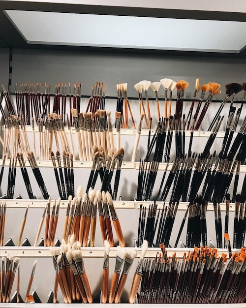 A professional makeup artist's meticulously organized workspace, showcasing an array of contour palettes, brushes, and sponges, emphasizing precision and variety.