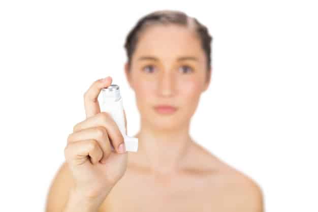 A close-up of a hand spritzing a setting spray over a flawlessly contoured face, demonstrating the final step for makeup longevity and a fresh finish.