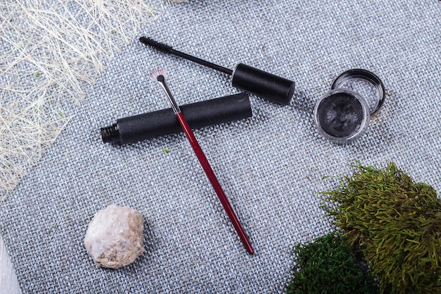 A collection of various eyeliner types—liquid pen, gel pot with an angled brush, and a classic liquid liner bottle—arranged neatly on a cosmetic tray, emphasizing precision tools for eyeliner application.