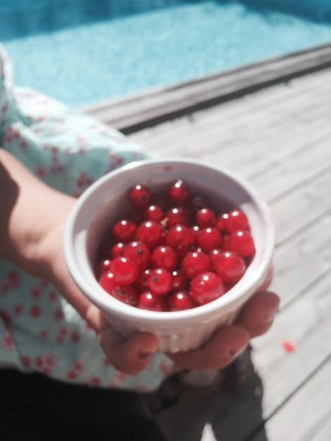 A close-up shot of vibrant, ripe tart cherries piled in a bowl, with a blurred background of an athlete stretching after a workout, symbolizing recovery and natural fuel.