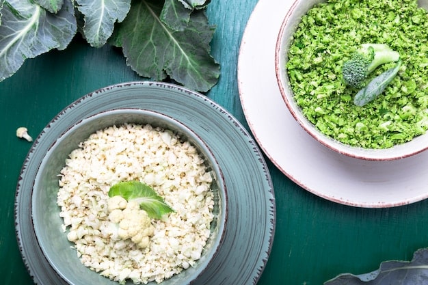 A close-up of a bowl filled with various whole grains, including quinoa, brown rice, and farro, with small green leaves and herbs suggesting freshness and nutritional value.