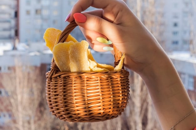A close-up of a person's hand reaching for a healthy snack from a picnic basket in a sunny outdoor setting, emphasizing mindful eating and natural light, with a focus on fresh, whole ingredients.