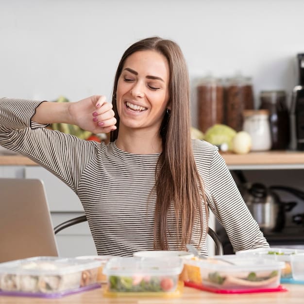 A person happily enjoying a healthy, prepped meal from a container while working at a tidy desk, demonstrating the convenience and focus it brings.