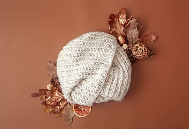 A flat lay of stylish winter accessories: a chunky knit beanie in muted beige, a plaid scarf with subtle navy and forest green hues, and a pair of soft, grey knit gloves, all neatly arranged on a rustic wooden surface.