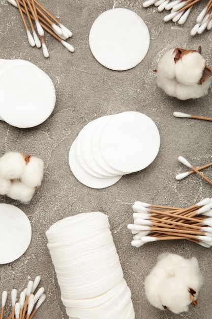 A variety of gentle, creamy facial cleansers in minimalist packaging, alongside soft cotton pads, arranged on a smooth, understated surface, with natural light.
