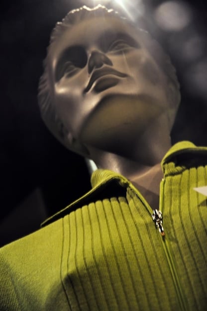 A close-up shot of a model on the Paris Fashion Week SS2025 runway wearing an oversized, deconstructed blazer in a neutral tone, paired with wide-leg trousers, emphasizing the blend of formality and comfort.