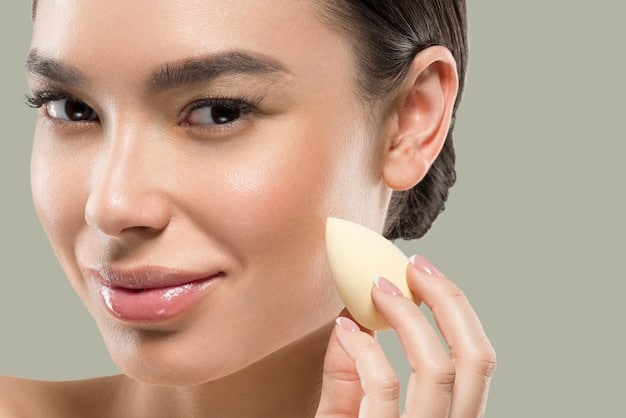 A woman demonstrates the correct technique for applying foundation with a makeup sponge. She is gently dabbing the sponge onto her cheek, blending the foundation seamlessly into her skin.