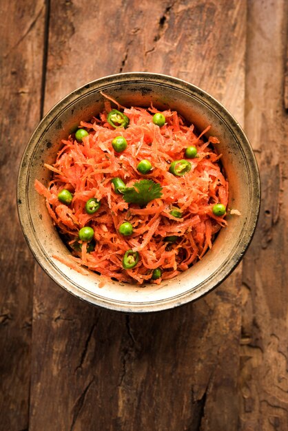 An overhead shot of a vibrant bowl of kimchi showcasing the variety of vegetables and spices used, with a shallow depth of field to highlight the texture and the fermentation process.