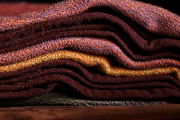 A close-up shot of various fall fabrics, including corduroy, tweed, and wool. The colors are muted and warm, with shades of brown, beige, and deep red. The fabrics are arranged to show their textures and patterns, reflecting Fall Fashion 2025: The Ultimate Guide to Layering Techniques and Color Palettes for a Stylish Season.