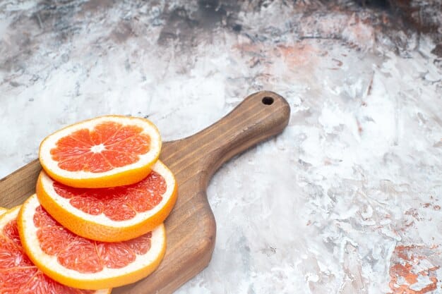 A close-up shot of freshly sliced oranges and grapefruits arranged on a cutting board, showcasing their vibrant colors and juicy texture. A glass of freshly squeezed orange juice is also visible in the background, emphasizing the theme of Fall Nutrition: 7 Immune-Boosting Foods to Prepare Your Body for the Colder Months is rich in Vitamin C.