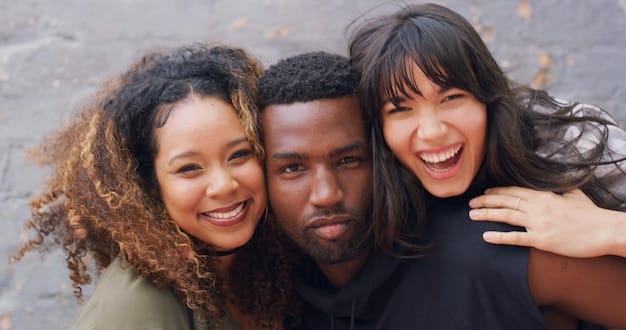 Close-up shot of a diverse group of young people, all smiling and looking confident, wearing various pieces of gender-neutral clothing. The clothing includes oversized sweaters, tailored pants, and button-down shirts in neutral colors.