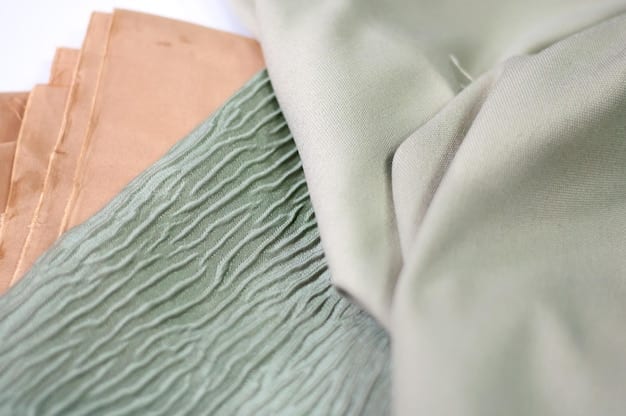A close-up shot featuring swatches of different sustainable fabrics like recycled polyester in muted grey, organic cotton in natural white, and plant-based pineapple leather. The textures and environmental benefits of each material are clearly visible.
