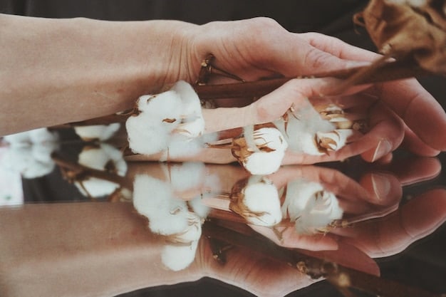 A close-up shot of hands gently touching a bolt of organic cotton fabric in a natural light setting, emphasizing its texture and purity, with a blurred background of a sustainable textile factory.